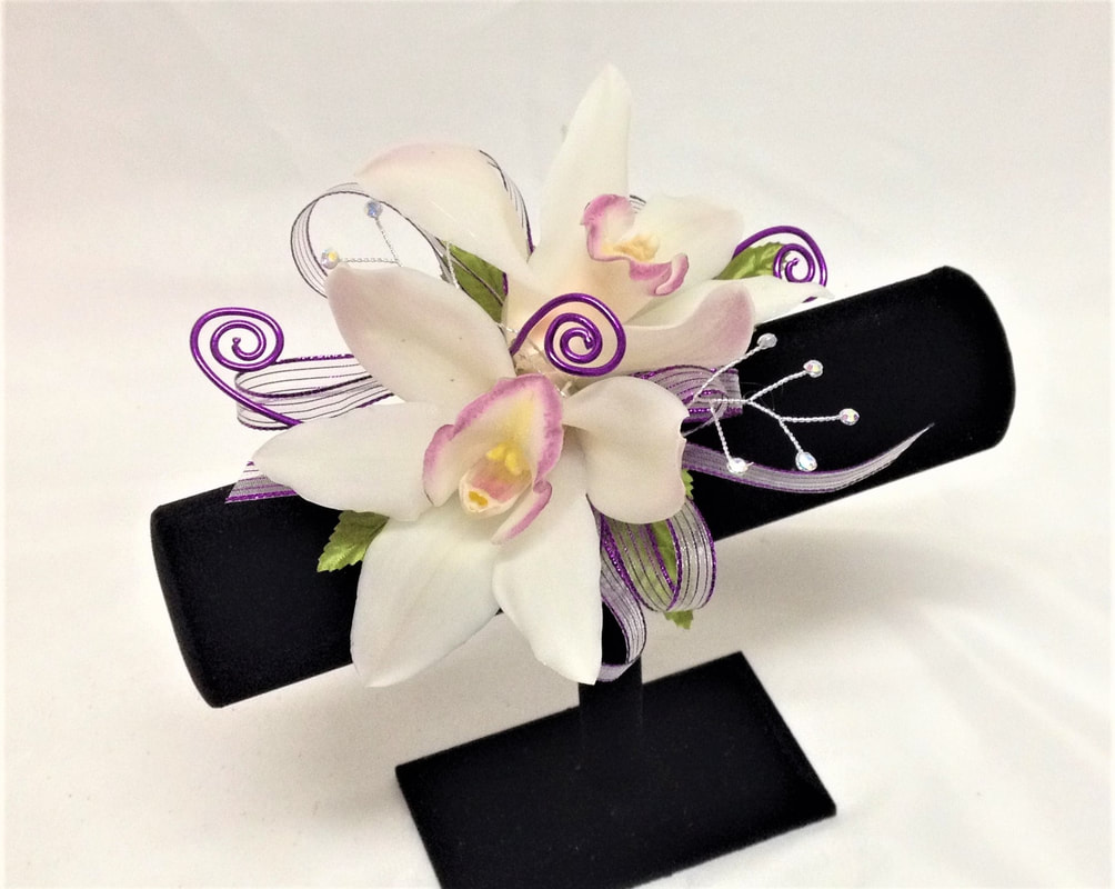 White orchid corsage with purple bow