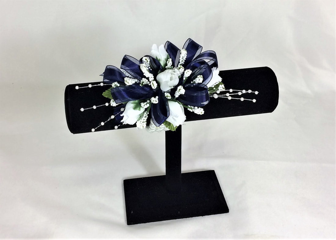 White spray rose corsage with navy bow