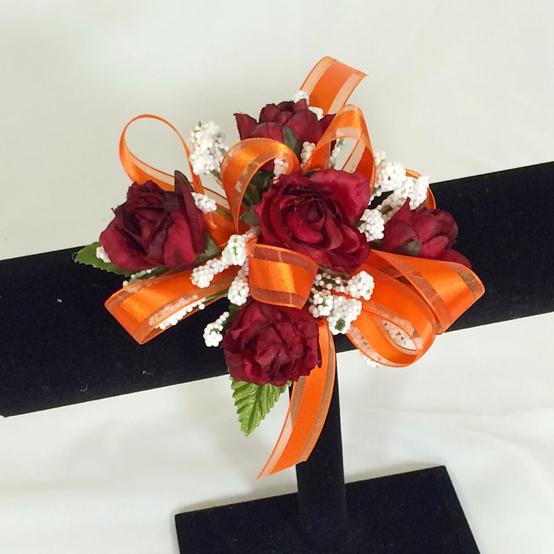 Burgundy rose corsage with orange bow