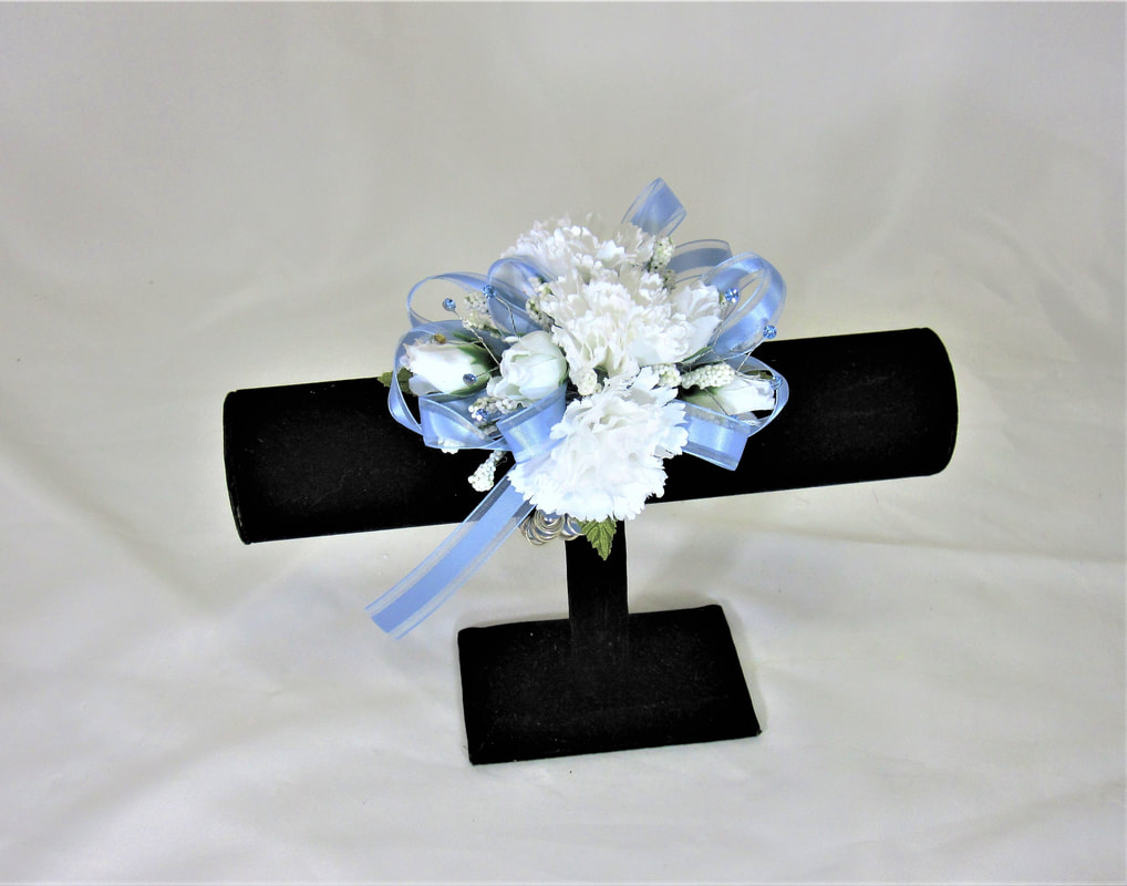 White carn corsage with light blue bow